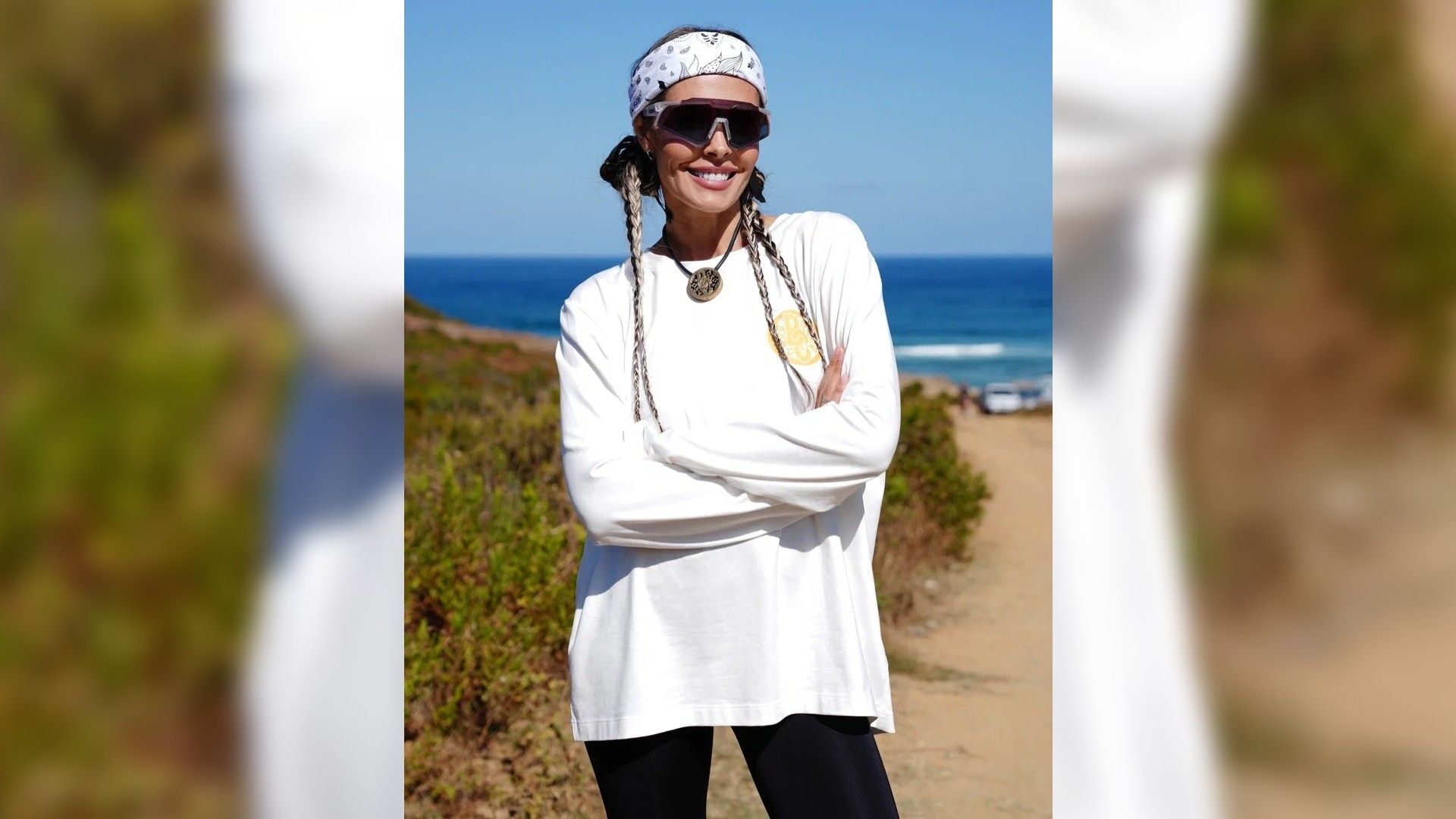 Маша Горбань в полный рост в белой кофте на фоне море