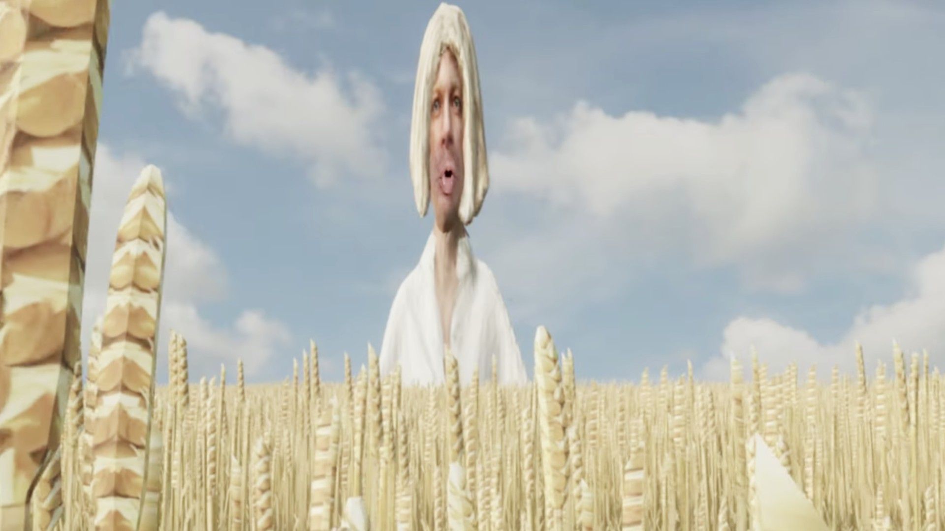 Нарисованный человечек в белой рубашке, с дредами и лицом Александра Гудкова возвышается над полем пшеницы