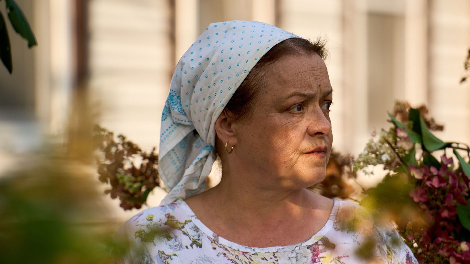 Елена Цыплакова в косынке и платье смотрит вбок