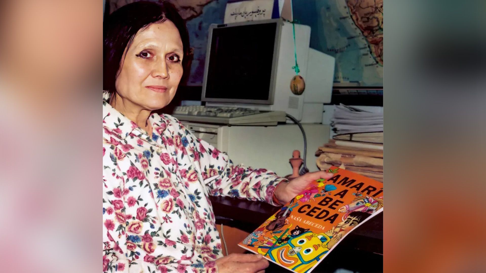 Лингвистка Милена Хюбшманнова сидит за письменным столом с книгой в руках