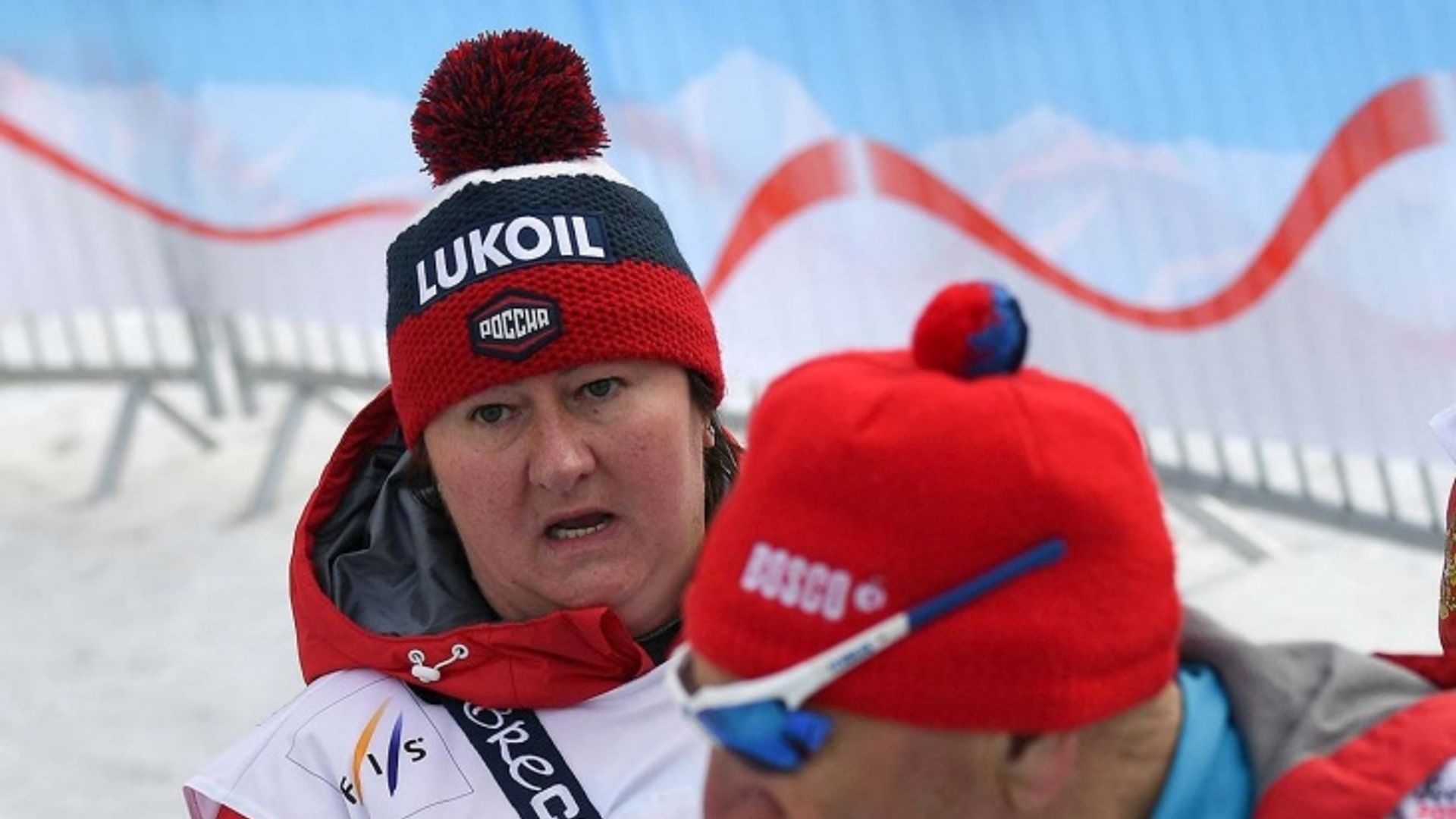 Елена Вяльбе в зимней шапке открывает рот и смотрит в сторону от камеры