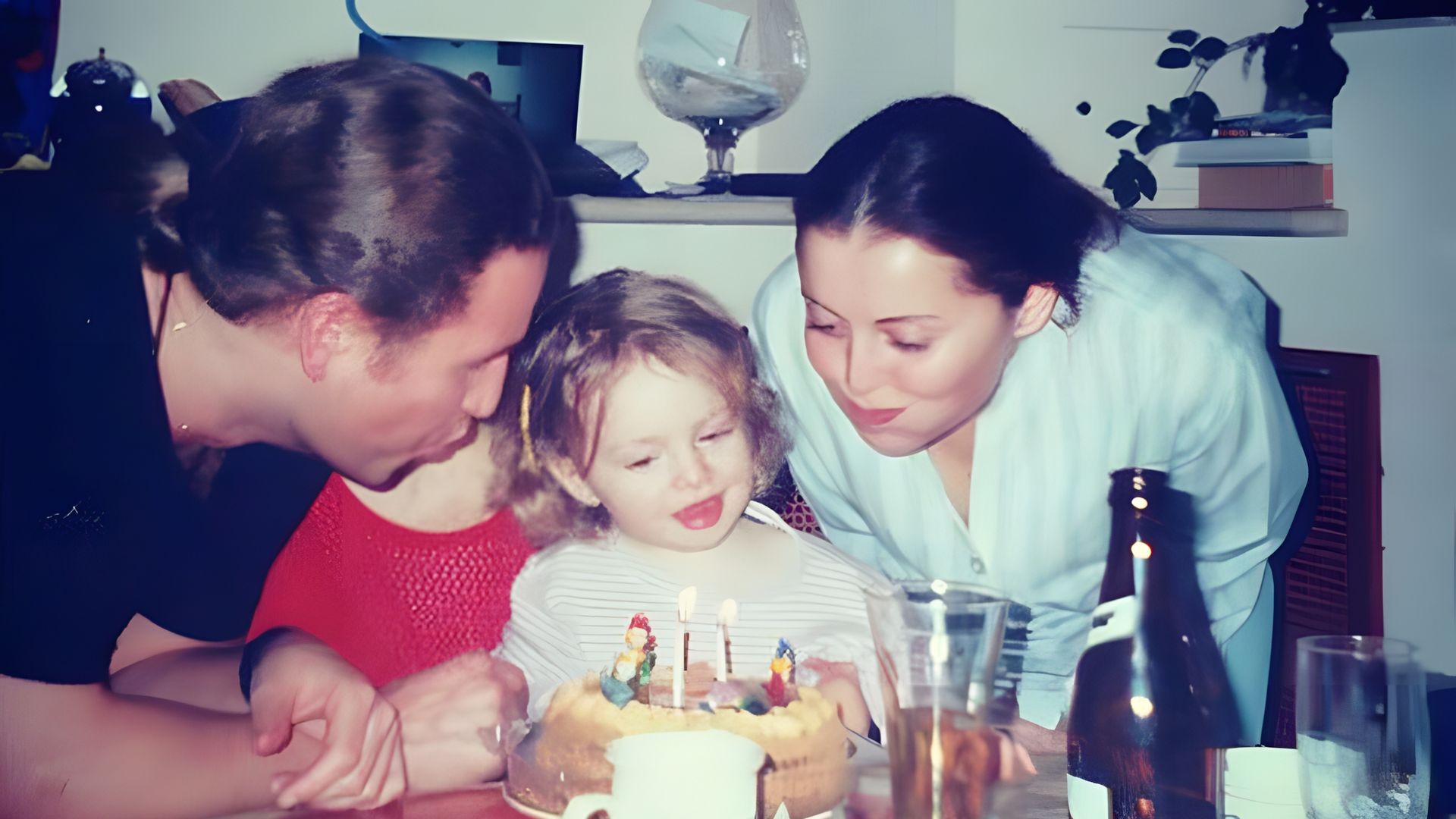 Леонид Агутин и Анжелика Варум целуют их доч Лизу, задувающую свечи на торте