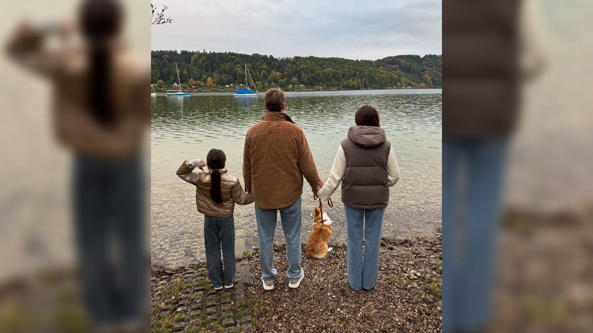 Алексей Воробьёв, Аида Гарифуллина, её дочь Аида и корги Моцарт стоят спиной к камере на фоне озера