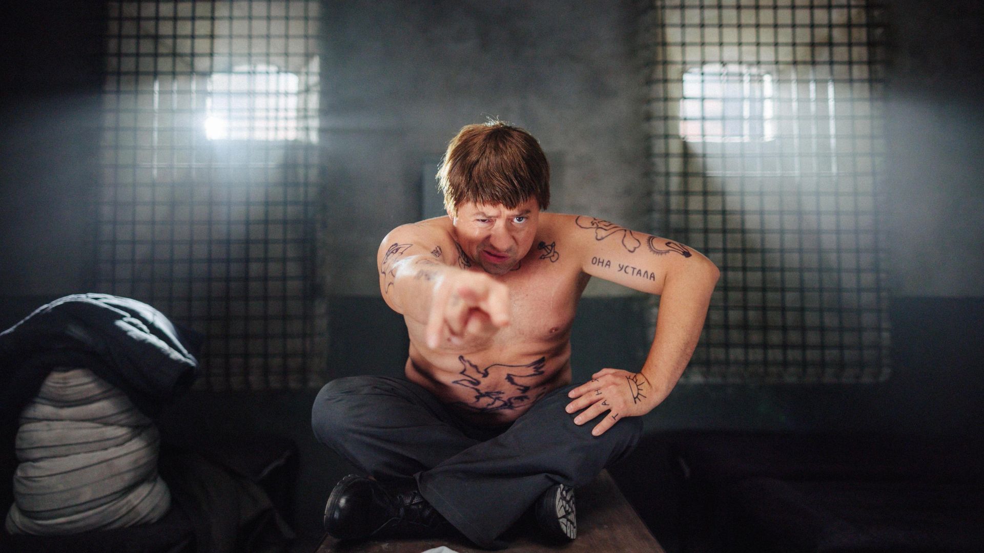 Андрей Гайдулян с тюремными татуировками сидит в позе лотоса