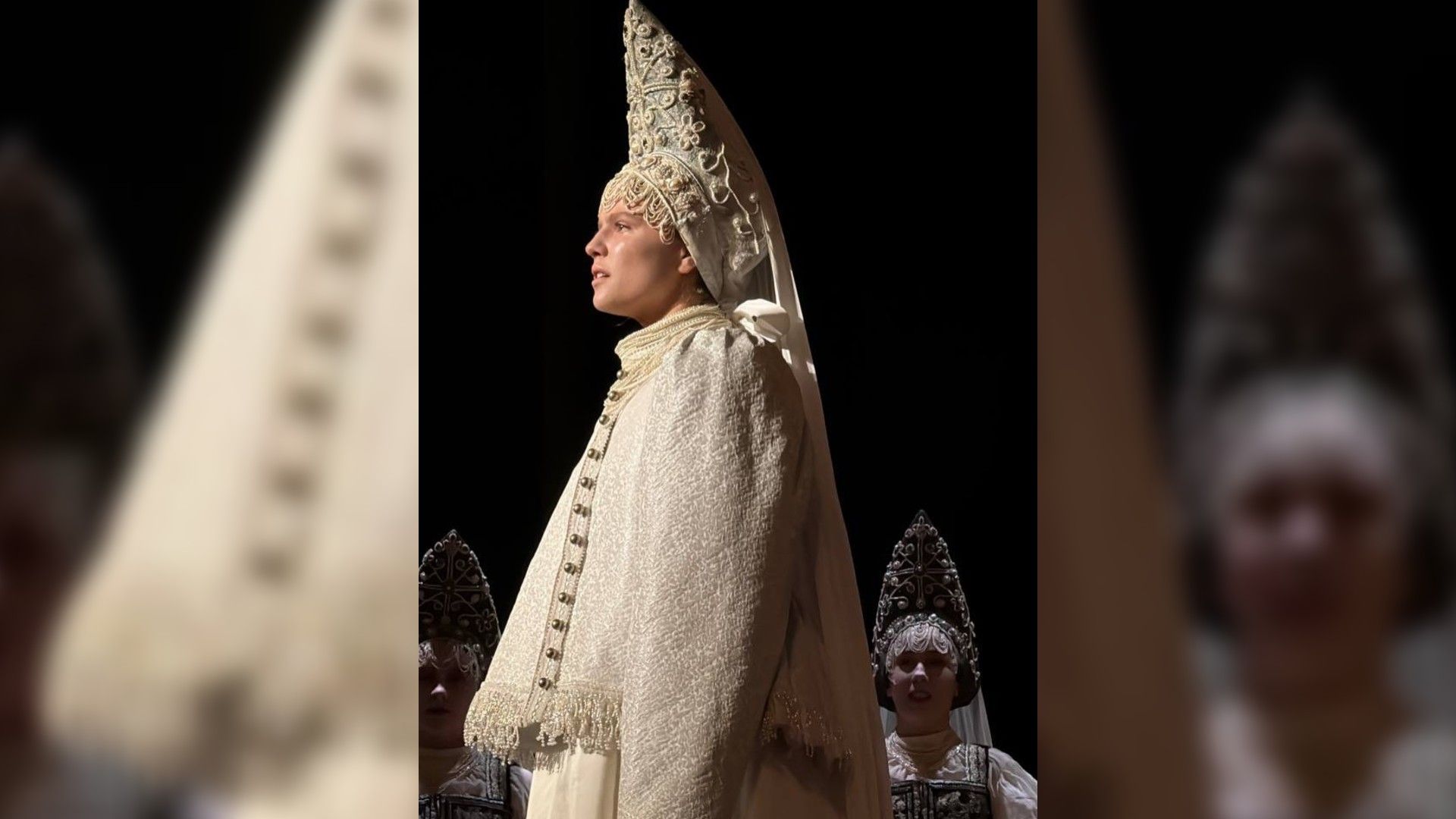 Ника Здорик в историческом костюме и кокошнике стоит на сцене боком к камере