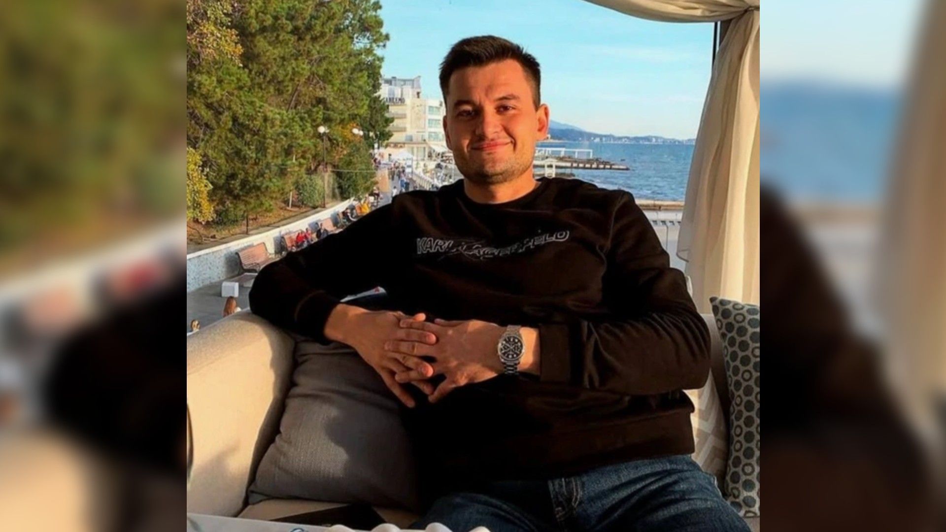 Мужчина сидит в беседке ресторана у моря