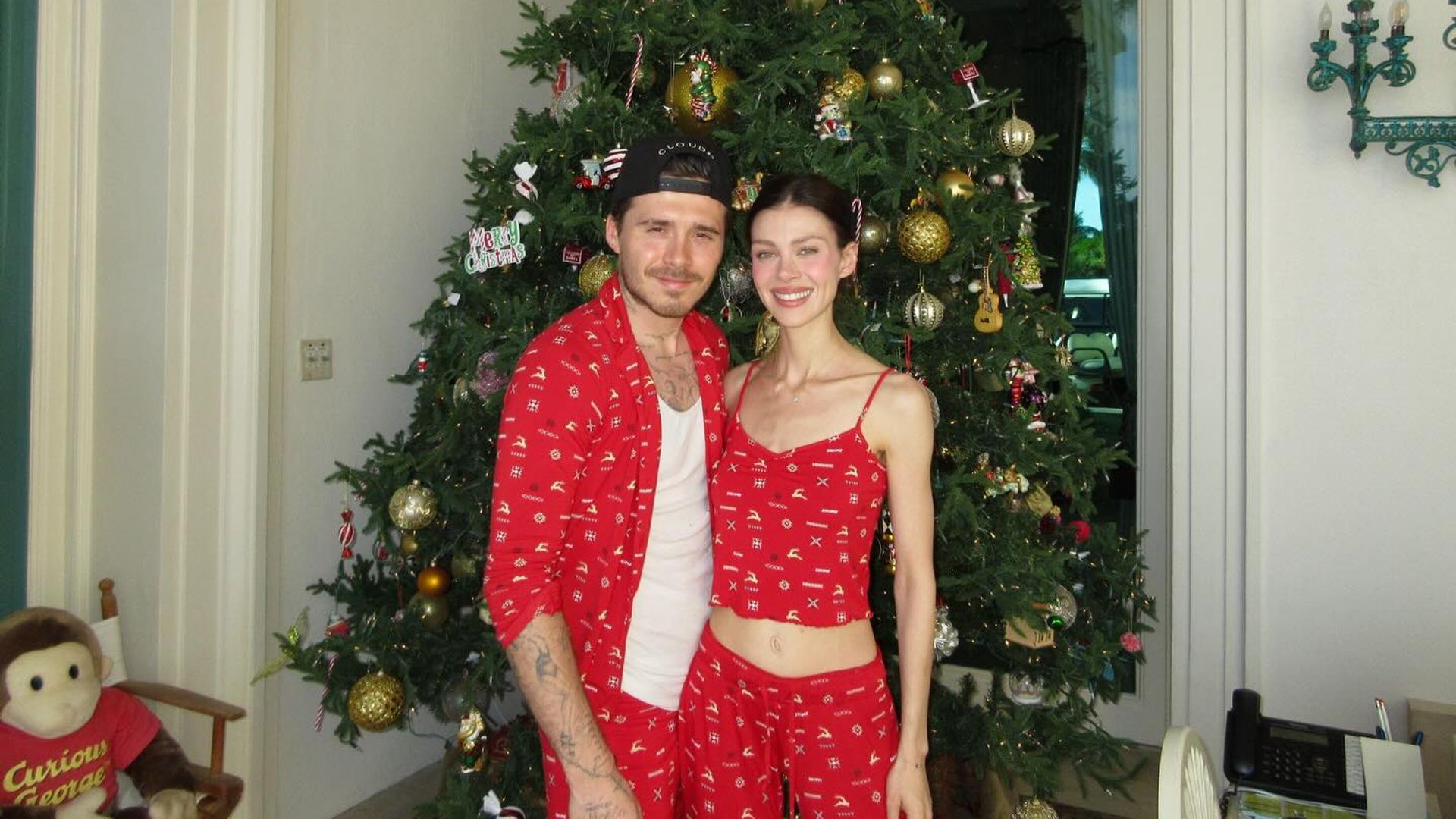 Бруклин Бекхэм и Никола Пельтц позируют на фоне новогодней елки