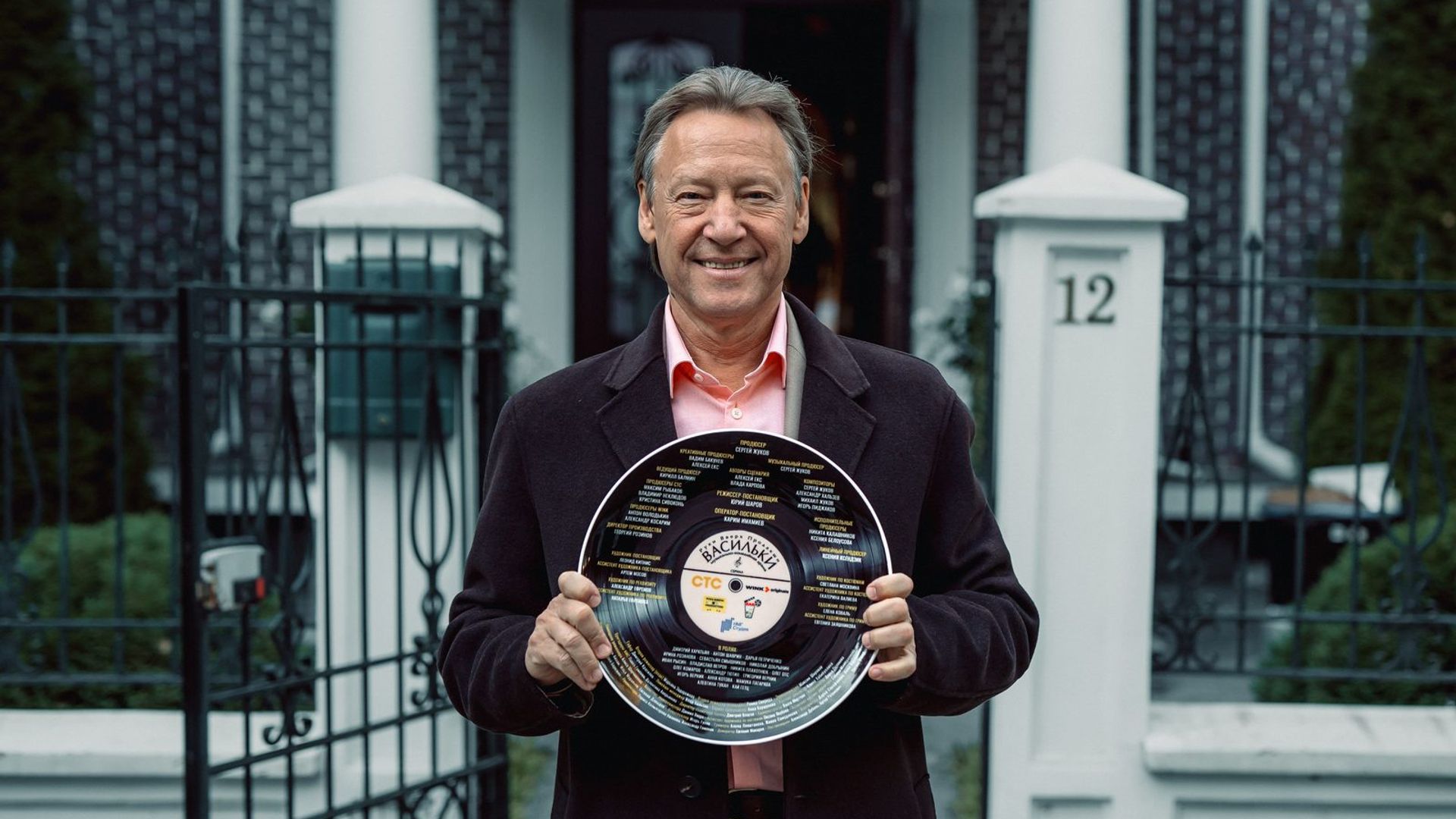 Дмитрий Харатьян держит в руках тарелку с надписью ВИА Васильки