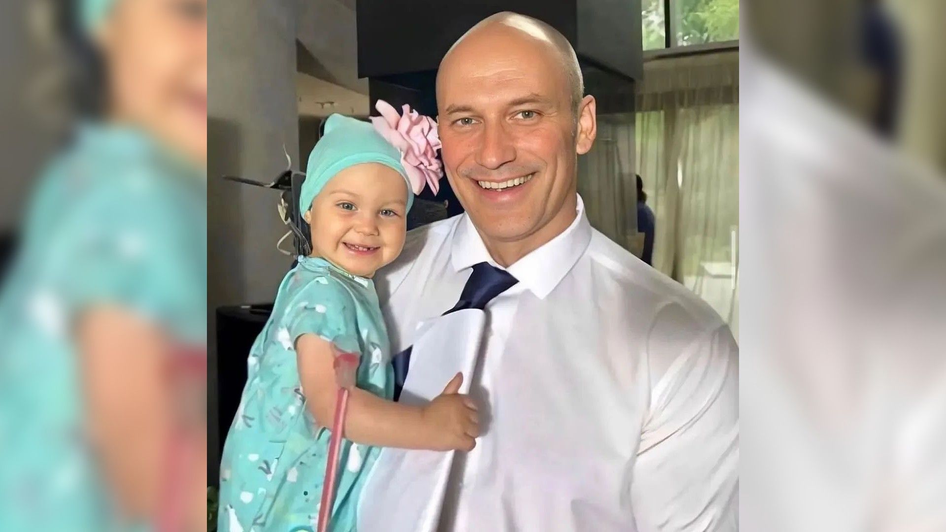 Константин Соловьёв держит на руках маленькую девочку