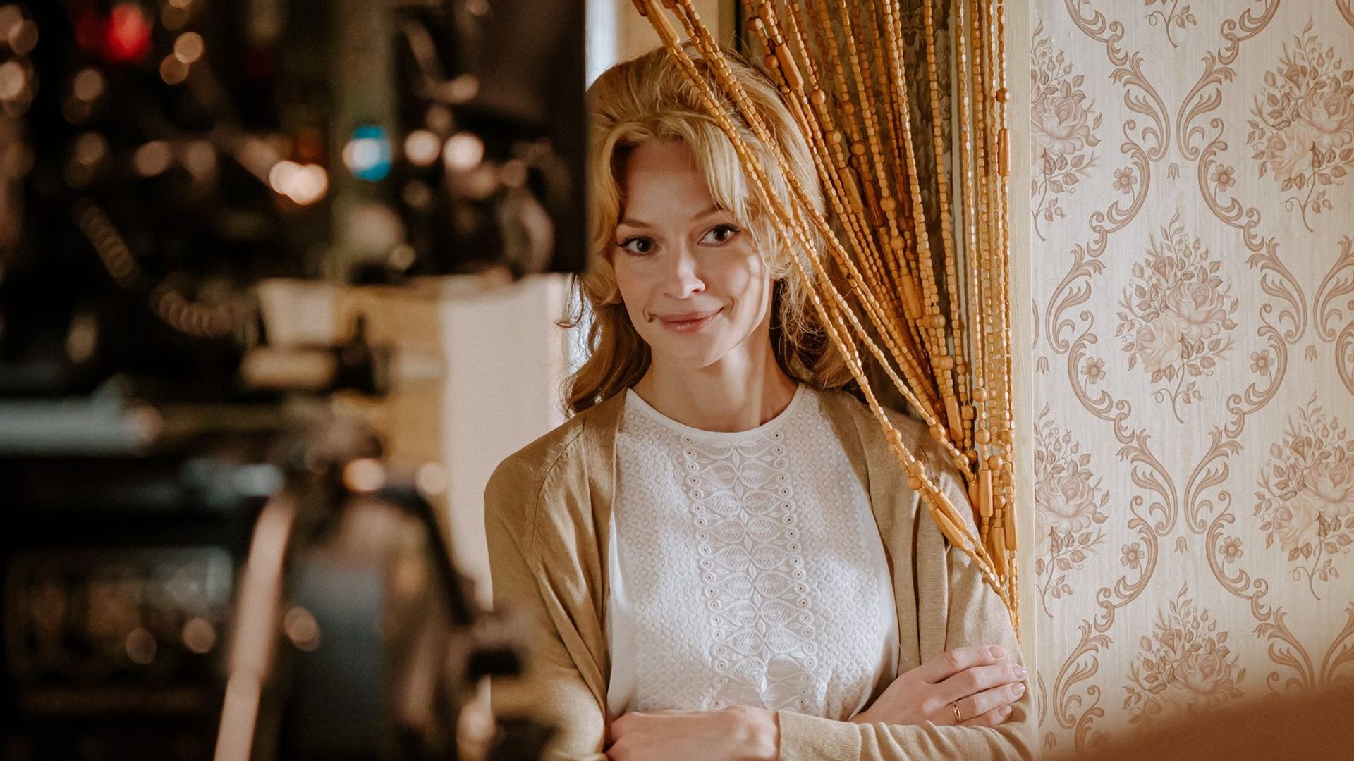 Светлана Ходченкова с причёской-бабеттой в бежевом кардигане стоит, сложив руки на груди