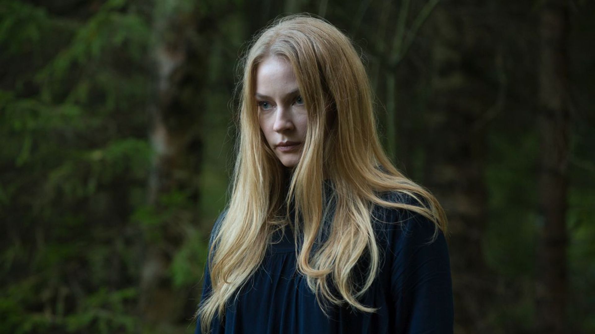Светлана Ходченкова с длинными волосами смотрит вперёд на фоне леса