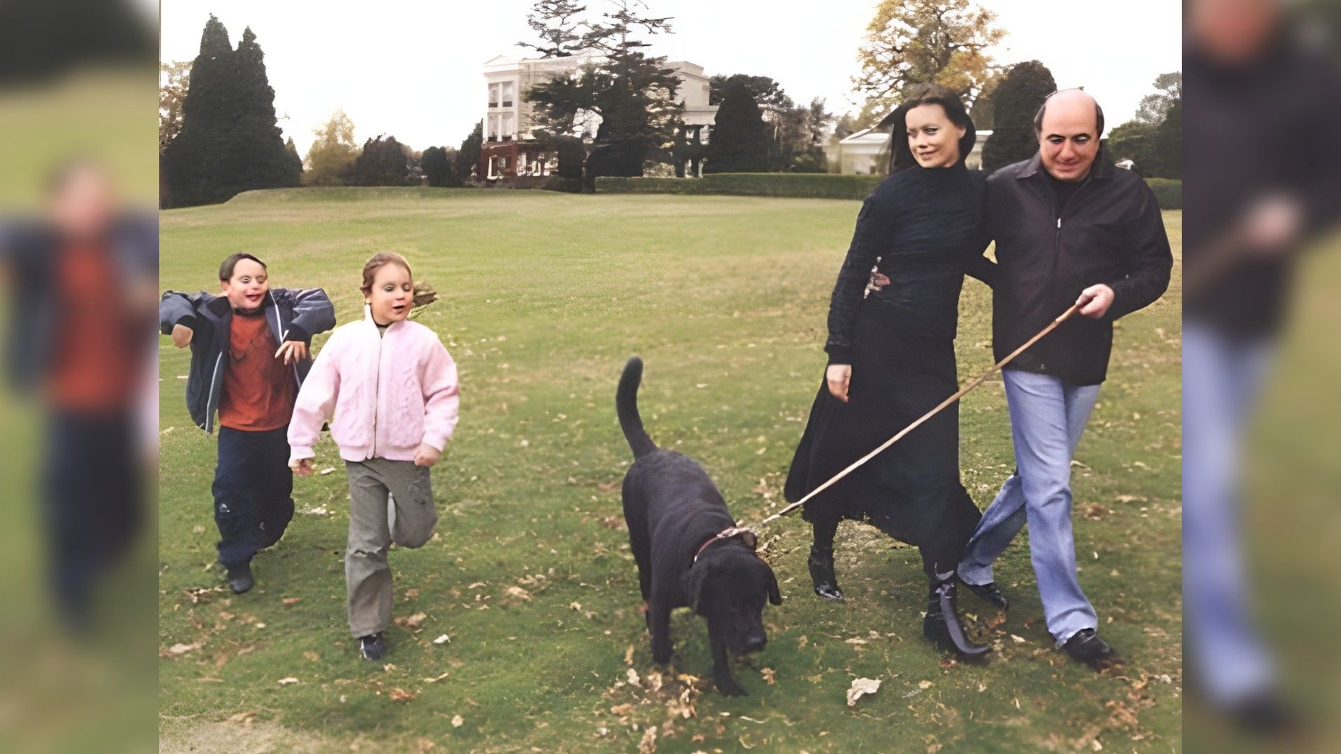 Борис Березвоский и женой Галиной и двумя маленькими детьми гуляет по парку с черным лабрадором