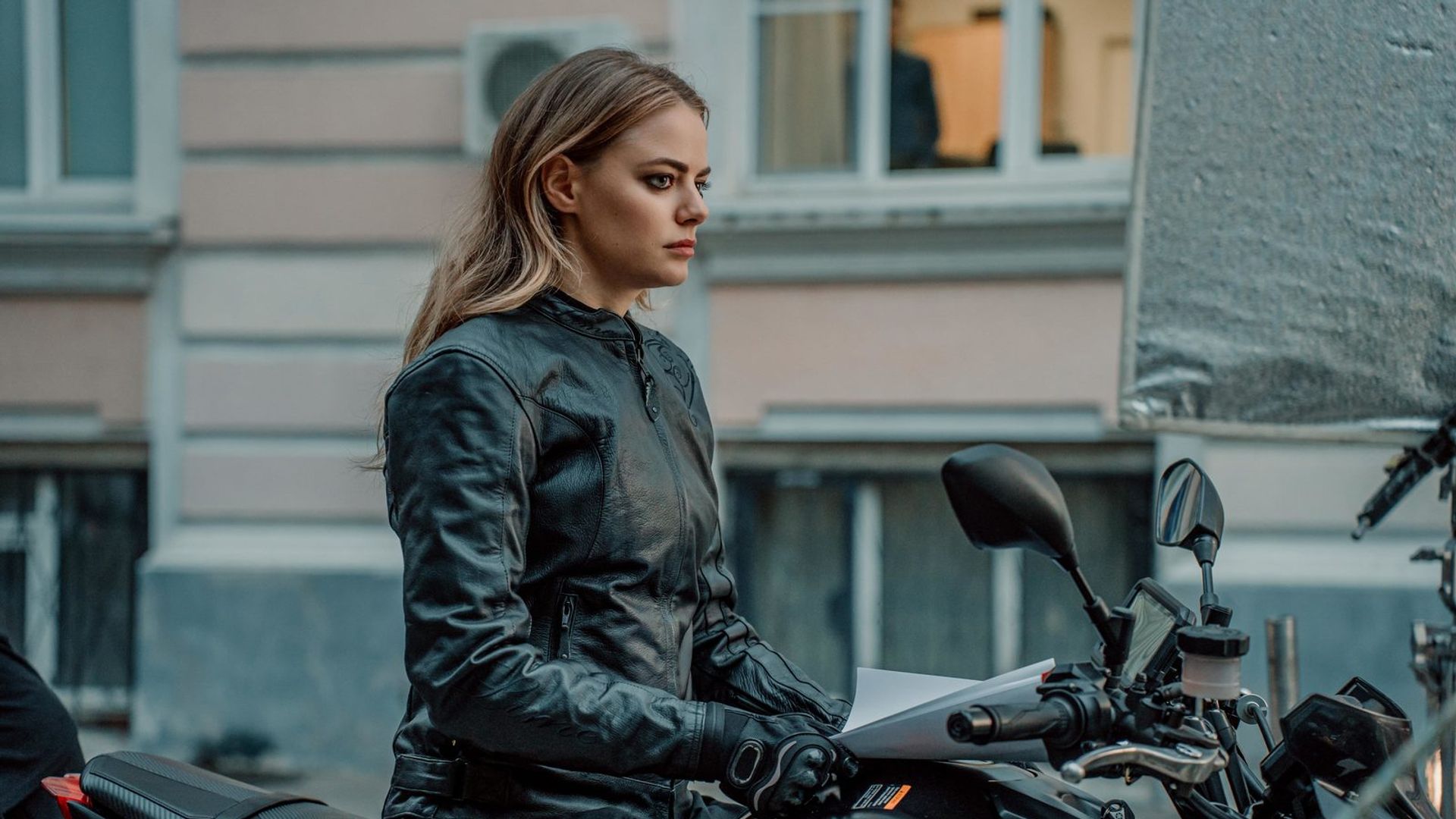 Маргарита Аброськина в кожаной куртке и байкерской экипировке сидит на мотоцикле