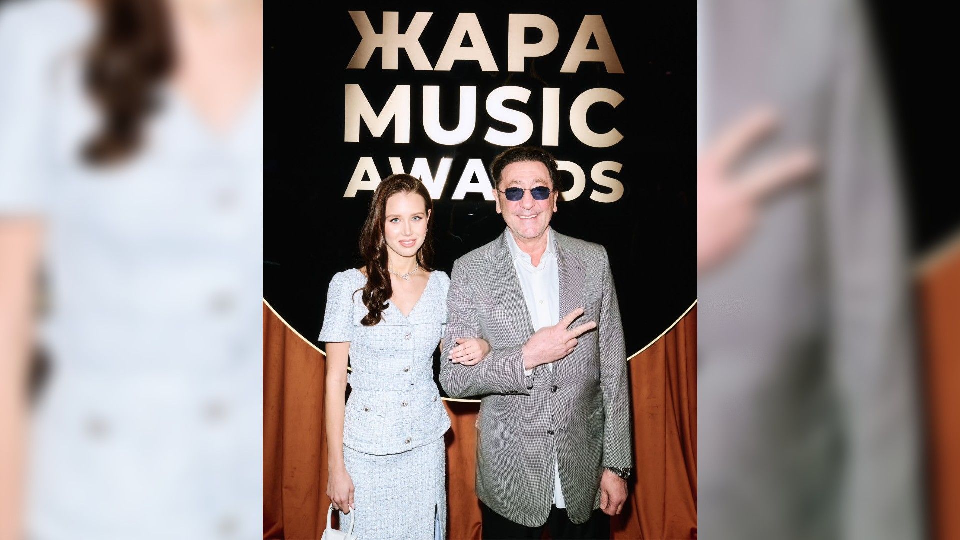 Аврора Киба и Григорий Лепс позируют в полный рост на фоне надписи ЖАРА