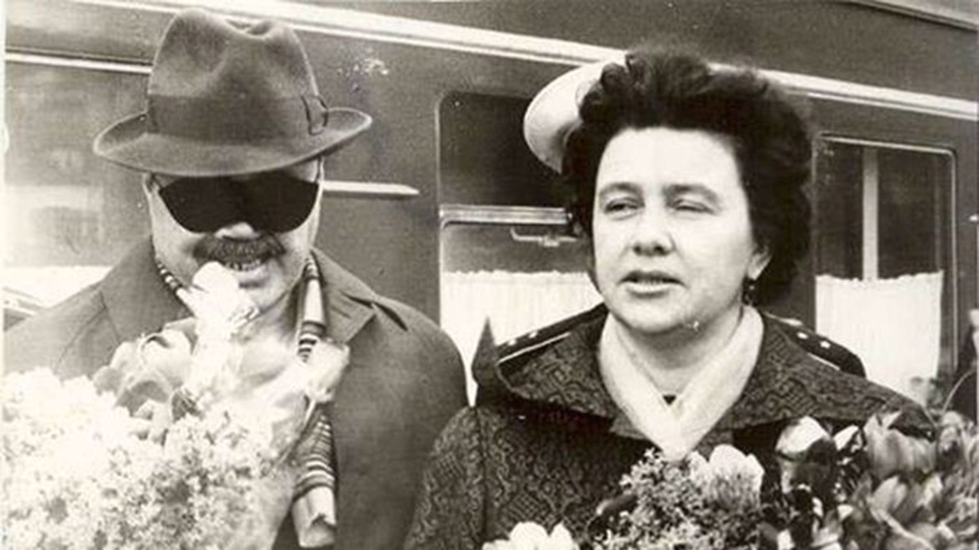 Эдуард Асадов и Галина Разумовская с букетами цветов возле вагона поезда