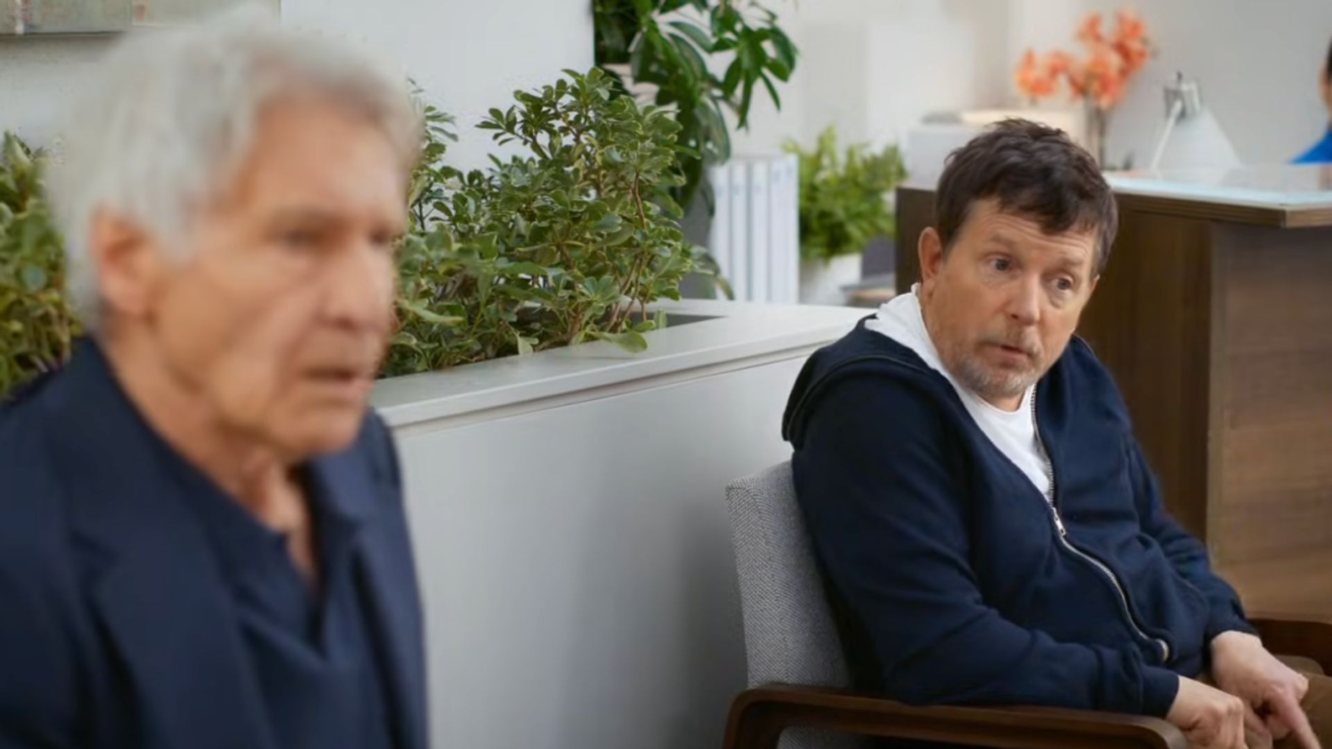 Харрисон Форд на переднем плане в размытом фокусе и Майкл Джей Фокс на заднем