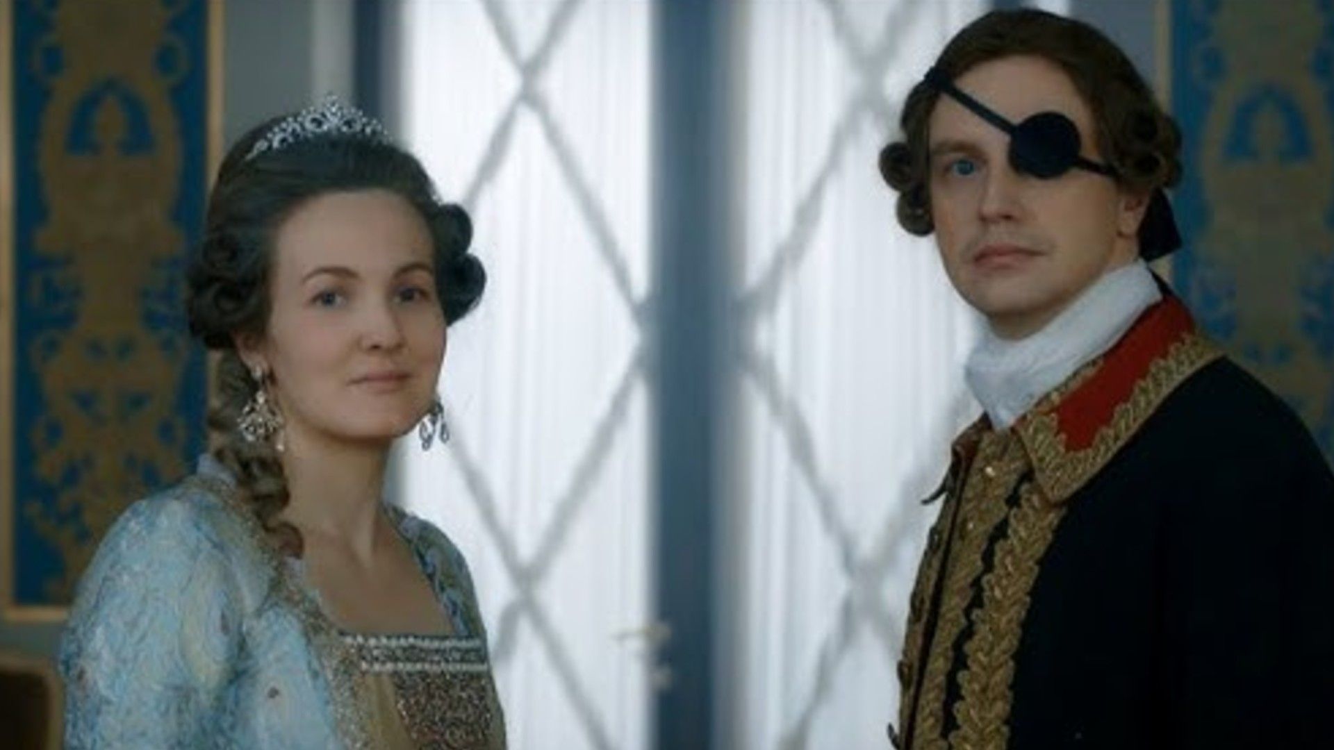 Актриса и актёр в исторических костюмах петровской эпохи смотрят в камеру