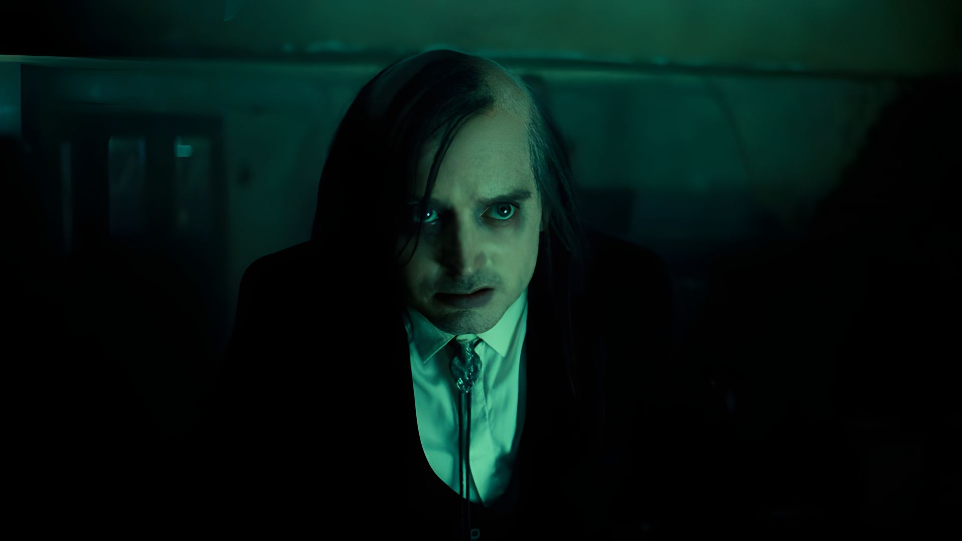 Элайджа Вуд с гримом и наполовину бритой головой смотрит в камеру исподлобья