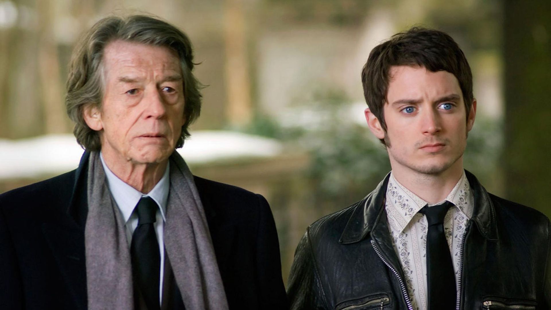 Джон Херт и Элайджа Вуд в костюмах удивленно смотрят вперед