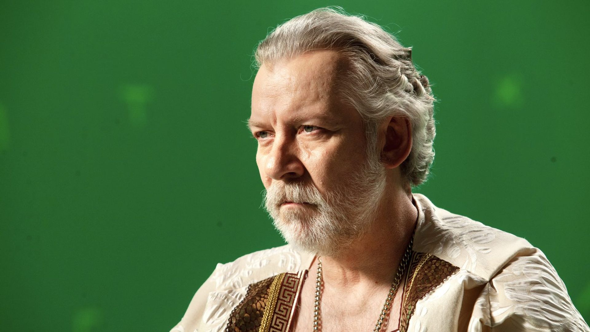 Виктор Раков смотрит вперед, длицо крупным планом, зеленый фон