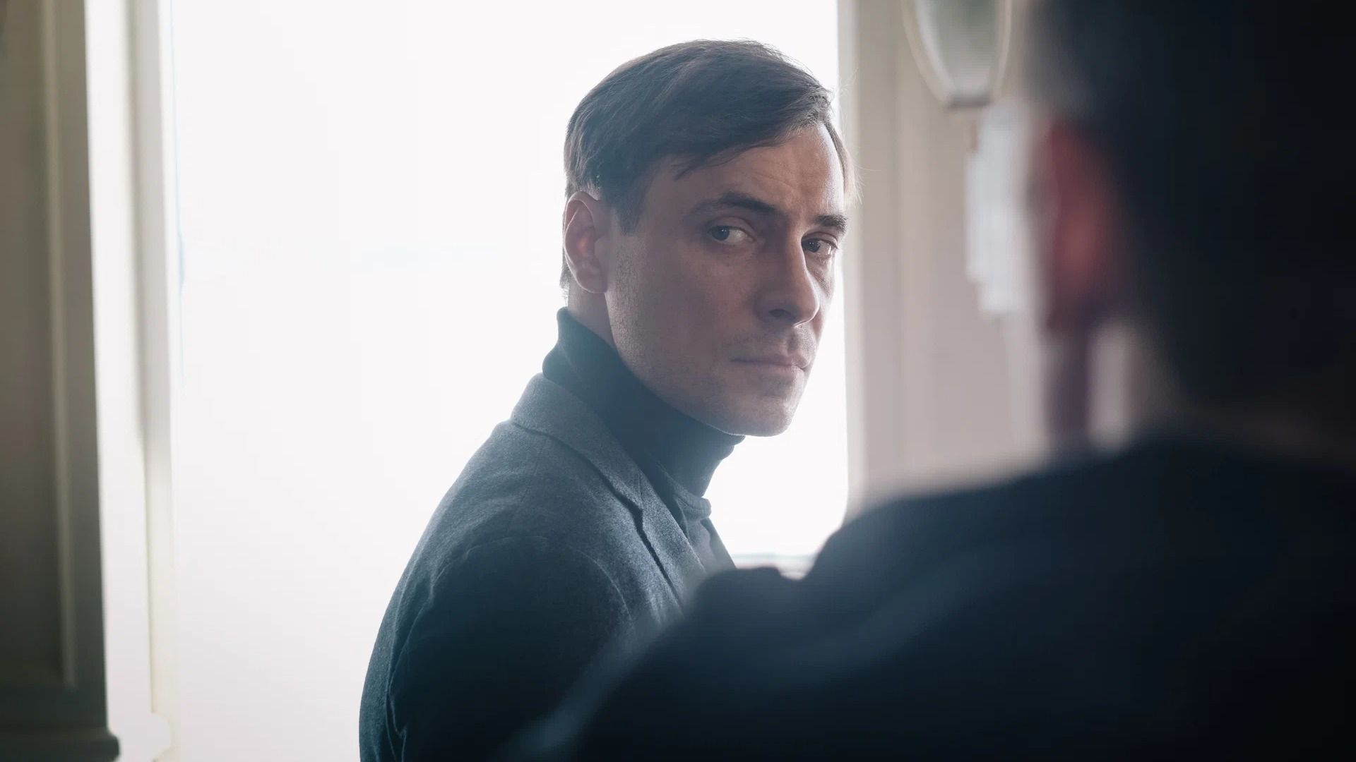 Актер Евгений Цыганов в черном пиджаке на съемках сериала "Мертвое озеро"